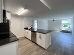 Located at 512 Merrimac Trail in Williamsburg, Virginia, this single-floor unit presents a clean, modern design characterized by light hardwood flooring and crisp white walls throughout. The open-concept layout connects the kitchen directly to the living area, creating a cohesive and functional living space.

The kitchen is well-appointed with white cabinetry, granite countertops, and a full suite of stainless steel appliances, including a refrigerator, electric range, and microwave. A peninsula counter extends into the living space, providing additional prep area and serving as a natural divider between the kitchen and the main living area. Recessed and fluorescent lighting keeps the kitchen bright and functional.

The living areas are generously proportioned, each featuring ceiling fans with integrated lighting and large windows that bring in natural light and outdoor views. The consistent light hardwood flooring runs throughout, contributing to a unified and airy ambiance.

The bathroom features neutral tile flooring, a granite-topped vanity with white cabinetry, and gold-toned hardware accents that add a subtle warmth to the otherwise clean, minimalist aesthetic. Overall, the space offers a contemporary, move-in-ready environment with consistent finishes and a bright, open feel.