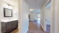 Located at 969 Hopmeadow St in Simsbury, Connecticut, this single-floor unit offers a clean, contemporary design with consistent wood-look flooring and a neutral color palette throughout. The open-concept layout connects the kitchen and living area seamlessly, creating a bright and functional living space. The kitchen is well-equipped with crisp white shaker cabinetry, a white subway tile backsplash, light countertops, and a full suite of stainless steel appliances, including a refrigerator, electric range, over-the-range microwave, and dishwasher. A peninsula-style counter provides additional workspace and visual separation between the kitchen and living area. The living space is airy and bright, benefiting from large windows and a sliding glass door that opens onto a private balcony, offering views of the surrounding landscape and allowing ample natural light to fill the room. A wall-mounted HVAC unit ensures year-round climate control. The bedroom is a comfortable, well-lit room with a window that brings in natural light and its own wall-mounted climate unit. The bathroom features dark espresso-toned cabinetry, a white undermount sink with a modern chrome faucet, a white countertop, and a framed mirror, all finished to a high standard. This unit combines modern finishes with practical design for comfortable everyday living.