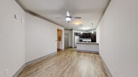 Located in Melbourne, FL, this thoughtfully designed one-bedroom, one-bathroom residence offers a functional and modern living experience across a single floor. The open-concept kitchen and living area serves as the heart of the home, featuring light wood-style flooring, crown molding, and a ceiling fan that enhances airflow throughout. The kitchen is outfitted with rich dark cabinetry, granite-style countertops, a peninsula with an undermount sink, pendant lighting, and a full suite of stainless steel appliances including a refrigerator, range, and microwave. The living area is bright and airy, with French doors that open to an outdoor balcony, inviting natural light and exterior views. The bedroom offers plush carpeting, a ceiling fan, and a dedicated window that brings in additional natural light. A spacious walk-in closet with multi-tier wire shelving provides ample storage. The bathroom includes a dark wood vanity with granite-style countertop, wood-look flooring, and a full tub-shower combination. A hallway connects the living spaces efficiently, completing this well-organized and contemporary residence.