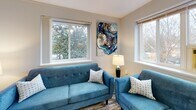 Located at 40 Crescent Rd in Greenbelt, Maryland, this single-floor residence offers a well-organized layout that balances comfort and functionality. The living area is a welcoming space, featuring hardwood flooring, multiple large windows that frame views of surrounding greenery, and abundant natural light. The room accommodates a seating arrangement with teal upholstered furniture and a window-mounted air conditioning unit, creating a cozy yet practical environment.

The kitchen is efficiently designed with dark cabinetry contrasted against light countertops, stainless steel appliances including a refrigerator and range, and a peninsula that provides additional workspace and casual seating. Light wood flooring and a large window with vertical blinds keep the kitchen bright and open.

The bedroom is generously sized with carpeted flooring, a ceiling fan with integrated lighting, and multiple windows on two walls that offer pleasant outdoor tree views and fill the room with natural light. A radiator along one wall provides supplemental heating.

The bathroom features a tiled tub-shower combination, clean white fixtures, and a small window above the tub that adds natural ventilation and light. Throughout the residence, neutral wall tones create a cohesive, calm ambiance suited to everyday living.