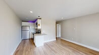 Located at 119 Sanders Ferry Road in Hendersonville, Tennessee, this 2-bedroom, 1-bathroom unit offers a thoughtfully updated interior with a clean, modern aesthetic. Light hardwood flooring flows consistently throughout the living spaces, complementing the warm neutral wall tones that create a cohesive and inviting atmosphere.

The kitchen is a standout feature, showcasing white shaker cabinetry, granite countertops, a herringbone tile backsplash, and a full suite of stainless steel appliances including a refrigerator, electric range, and over-the-range microwave. The combined kitchen and living room area provides an efficient, open layout well-suited for everyday living.

The spacious primary bedroom offers generous proportions, with large windows that invite abundant natural light and views of the surrounding greenery. The second bedroom also features a window with outdoor views and baseboard heating. Both bedrooms are finished with the same light hardwood flooring and neutral palette found throughout the unit.

The bathroom features marble-look tile flooring, a white vanity with a solid surface countertop, brushed nickel fixtures, and a tiled shower, presenting a clean and contemporary finish. Recessed lighting in the living area adds a polished touch to this well-appointed home.