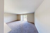 Located at 7099 Granada Dr in Flint, Michigan, this single-floor, 2-bedroom, 2-bathroom home offers a practical and comfortable layout designed for easy everyday living. The floor plan flows from a welcoming entrance through a hallway connecting all main areas of the home.

The living room is a generous, open space finished with plush carpeting and neutral beige walls. A sliding glass door with vertical blinds fills the room with natural light and provides direct access to an outdoor balcony or patio area with views of the surrounding greenery. An adjacent dining room connects seamlessly to the galley-style kitchen, which features white cabinetry with wood-tone accents, a stainless steel sink, white appliances including a coil-burner range and refrigerator, and durable hardwood-style flooring.

The primary bedroom is a well-proportioned retreat with carpeted floors and the added convenience of a walk-in closet. The second bedroom also features carpet, neutral walls, and a wood-paneled bi-fold closet door. In total, four closets are distributed throughout the home, providing ample storage. Both bathrooms are clean and functional, each featuring a vanity with a large mirror. A hallway connects the private bedroom wing to the main living areas, contributing to a well-organized layout throughout the home.