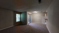 Located at 5724 Riverdale Road in College Park, GA, this 2-bedroom, 2-bathroom unit offers a thoughtfully arranged single-floor layout designed for functional living. The entrance opens into a carpeted living room featuring neutral-toned walls, white panel doors, a textured ceiling, and a window that brings in natural light. The galley-style kitchen is well-appointed with warm wood cabinetry, dark granite-style countertops, light hardwood-style flooring, and black appliances including a gas range, dishwasher, and refrigerator — providing ample storage and prep space. Both bedrooms are carpeted with neutral walls and textured ceilings. The primary bedroom is generously sized and connects to a walk-in closet outfitted with wire shelving for organized storage. The primary bathroom features warm wood vanity cabinetry, a granite-style countertop, a large mirror with overhead lighting, and hardwood-style flooring. The second bathroom includes a full tub-shower combination with white tile surround. A dedicated laundry area adds everyday convenience. Throughout the unit, consistent neutral tones and clean white trim create a cohesive and move-in-ready atmosphere.