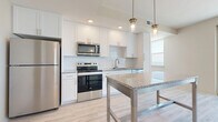 Located in Daytona Beach, FL, this well-appointed 2-bedroom, 2-bathroom residence offers a thoughtfully designed single-floor layout with a clean, modern aesthetic throughout. The open-concept kitchen and living area serves as the heart of the home, where the kitchen impresses with crisp white shaker cabinetry, white subway tile backsplash, granite countertops, stainless steel appliances, and a granite-topped island with pendant lighting — all set above light wood-look flooring that flows seamlessly through the main living areas. The living room is a true highlight, featuring a sleek built-in electric fireplace and large windows framing breathtaking, unobstructed ocean views. Glass panel doors open directly to a private balcony, bringing the coastal scenery indoors. The primary bedroom offers direct access to a well-finished en-suite bathroom, complete with granite vanity countertops and modern fixtures, and includes a spacious walk-in closet with wire shelving. The second bedroom features plush carpeting and ample natural light. Both bathrooms are finished with granite countertops, wood-look flooring, and contemporary hardware. With two closets, recessed lighting, and sweeping Atlantic Ocean views, this residence delivers an elevated coastal living experience.