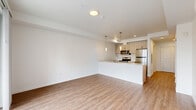 Located in Lynnwood, Washington, this thoughtfully designed single-floor unit offers a clean, modern aesthetic with a bright, open layout. The combined kitchen and living area serves as the heart of the space, where light wood-tone flooring runs continuously underfoot, creating a warm and cohesive feel. The kitchen is outfitted with light wood cabinetry, a sleek quartz peninsula with an integrated sink, stainless steel appliances including a refrigerator, electric range, and built-in microwave, and stylish pendant lighting that adds a contemporary touch. The open living area is bathed in natural light from large sliding glass doors that lead directly onto a private balcony with a metal railing, offering views of the surrounding neighborhood. A wall-mounted mini-split system provides efficient climate control throughout the space. The bathroom features a clean, all-white design with a combination tub and shower with a rain-style showerhead, warm wood-tone flooring, and a modern vanity. Crisp white walls and recessed lighting throughout give the unit a fresh, move-in-ready appearance, making it a well-appointed and functional home in a convenient Lynnwood location.