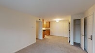 This single-floor residence at Markwell Village offers a practical and well-organized layout designed for comfortable everyday living. The open living area is finished with neutral-toned wall-to-wall carpeting and clean white walls, creating a bright and versatile space that flows seamlessly toward the kitchen pass-through. Natural light enters through windows fitted with horizontal blinds, adding a sense of openness to the interior.

The galley-style kitchen is efficiently designed with warm wood cabinetry, granite-look countertops, and stainless steel appliances including a refrigerator, range, microwave, and dishwasher. Light ceramic tile flooring and pendant lighting complete the kitchen's functional aesthetic. A dedicated storage area is accessible directly from the kitchen, providing additional organizational space.

The bedroom areas are carpeted and include generous closet storage — one room features a double-door closet with built-in shelving, while another includes a standard reach-in closet. Each bedroom benefits from natural light through exterior-facing windows.

The bathroom is finished with neutral ceramic tile on both the floor and tub surround, paired with a full-size soaking tub and shower combination. The overall design throughout the unit maintains a cohesive, understated palette that provides a clean and move-in-ready environment.