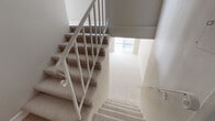 Located in the heart of Beverly Hills, this two-floor residence at 115 N Doheny Drive offers a clean, neutral aesthetic throughout. The layout spans two levels connected by a carpeted staircase with a classic white metal railing, providing a smooth transition between the floors.

The living areas are finished with plush wall-to-wall carpeting and painted in warm, neutral tones that create a bright and welcoming atmosphere. Large windows dressed with vertical blinds allow generous natural light to fill the rooms. A stylish multi-globe pendant chandelier serves as a focal point in one of the main living spaces, adding a modern touch.

The galley-style kitchen is well-appointed with light wood cabinetry, granite-style countertops, and white appliances including a range, microwave, and dishwasher. Tiled flooring and dual windows keep the space bright and functional, with a door providing convenient access.

The bedrooms are spacious and carpeted, each offering ample room and natural light through wide windows with vertical blinds. Built-in closets with shelving provide practical storage solutions.

The bathrooms feature tile flooring, glass-enclosed showers, granite-style vanity countertops with white cabinetry, and large mirrors. The overall design is clean and functional, reflecting a well-maintained interior in a prime Beverly Hills location.