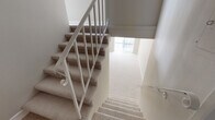 Located in the heart of Beverly Hills, this two-floor residence at 115 N Doheny Drive offers a clean, neutral aesthetic throughout. The layout spans two levels connected by a carpeted staircase with a classic white metal railing, providing a smooth transition between the floors.

The living areas are finished with plush wall-to-wall carpeting and painted in warm, neutral tones that create a bright and welcoming atmosphere. Large windows dressed with vertical blinds allow generous natural light to fill the rooms. A stylish multi-globe pendant chandelier serves as a focal point in one of the main living spaces, adding a modern touch.

The galley-style kitchen is well-appointed with light wood cabinetry, granite-style countertops, and white appliances including a range, microwave, and dishwasher. Tiled flooring and dual windows keep the space bright and functional, with a door providing convenient access.

The bedrooms are spacious and carpeted, each offering ample room and natural light through wide windows with vertical blinds. Built-in closets with shelving provide practical storage solutions.

The bathrooms feature tile flooring, glass-enclosed showers, granite-style vanity countertops with white cabinetry, and large mirrors. The overall design is clean and functional, reflecting a well-maintained interior in a prime Beverly Hills location.