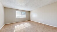 Located at 1533 Merchant St in Emporia, Kansas, this single-story home offers five bedrooms and one bathroom within a practical and efficiently arranged floor plan. The layout connects all rooms through a central hallway, providing straightforward access throughout the home.

The bedrooms are carpeted throughout and feature neutral beige walls, white baseboards, and textured ceilings. Most bedrooms are equipped with windows dressed in horizontal blinds, allowing natural light to brighten each room. The spacious primary bedroom stands out for its generous proportions and sun-filled atmosphere. Several bedrooms include closets with built-in hanging rods, offering useful storage solutions.

The kitchen features gray cabinetry — both upper and lower — paired with light countertops, a single-basin sink, and a white electric range with overhead ventilation. The flooring is finished in light-toned tile, contrasting the carpeted living areas.

The bathroom includes a full-size soaking tub with a shower, a window for natural light and ventilation, a white vanity with an integrated sink, and tile flooring. The overall aesthetic throughout the home is clean and understated, with consistent neutral tones creating a cohesive, move-in-ready environment suitable for a variety of occupants.