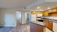 Located at 6650 Creek Bay Dr in Indianapolis, Indiana, this single-floor, 2-bedroom, 1-bathroom home offers a functional and well-organized layout. The open-concept kitchen and living area serves as the heart of the home, featuring warm honey-toned cabinetry, dark granite-style countertops, a kitchen island with a breakfast bar overhang, and white appliances including a refrigerator, electric range, built-in microwave, and dishwasher. Wood-look laminate flooring flows throughout the main living areas, adding a clean, cohesive feel. The living area is bright and airy, highlighted by a sliding glass door that fills the space with natural light and provides outdoor access. Both bedrooms are carpeted and offer natural light through windows with blinds. The primary bedroom includes a closet with louvered bifold doors. The full bathroom is well-appointed with a single-sink vanity with dark countertops, matching wood cabinetry, and a tub-shower combination. Additional highlights include three closets for ample storage, a dedicated laundry area, and a utility room. Recessed lighting in the kitchen adds a polished touch to this practical and comfortable home.