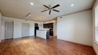 Located at 23600 Farm to Market 1093 in Richmond, TX, this single-floor residence offers a thoughtfully designed open-concept layout. The main living area features warm hardwood-style flooring, recessed lighting, and a ceiling fan, creating a bright and comfortable atmosphere. A front entryway with a transom window welcomes natural light into the space.

The kitchen is a functional centerpiece of the home, equipped with rich dark cabinetry, granite-style countertops, black appliances including a refrigerator, range, and microwave, and a central island with pendant lighting overhead. The kitchen flows seamlessly into the living and dining areas, making it ideal for entertaining.

The bedrooms are carpeted for comfort and feature generous natural light through large windows with blinds. At least one bedroom includes a spacious walk-in closet outfitted with wire shelving and hanging rods, providing ample storage. An additional bedroom benefits from a large multi-panel window arrangement that allows abundant natural light.

The bathroom is well-appointed with tile flooring, a soaking tub with tile surround, a separate glass-enclosed shower, a vanity with dark cabinetry, and a framed mirror. Throughout the residence, neutral tones and clean finishes contribute to a cohesive and inviting aesthetic.