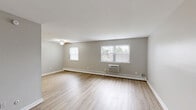 Located at 1700 W Street Rd in Warrington, PA, this single-floor, 1-bedroom, 1-bathroom unit offers a practical and comfortable layout with clean, neutral finishes throughout. The spacious living room is bathed in natural light from multiple windows dressed with vertical blinds, and features light-toned hardwood-style flooring, a ceiling fan, and a baseboard heating system complemented by a wall-mounted air conditioning unit. The functional kitchen is equipped with warm wood cabinetry, dark granite-style countertops, a dark tile backsplash, and a full suite of white appliances including a gas range, built-in microwave, dishwasher, and refrigerator — all set atop matching hardwood-style flooring. The bedroom is generously sized, finished with plush wall-to-wall carpeting, a window with outdoor views, and notable storage with multiple closets, including a walk-in closet. The full bathroom features floor-to-ceiling white tile surrounding a soaking tub, with a window providing natural light. A hallway connects the rooms, and three total closets provide ample storage throughout. The unit's consistent neutral gray palette, clean lines, and practical amenities create a calm and functional living environment.