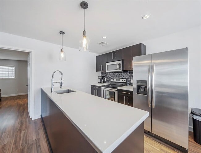 Kitchen features updated stainless appliances and backsplash for a sleek, modern look. - 309 Stratford St