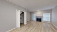 This two-floor residence offers a thoughtfully designed interior with a neutral color palette and a variety of finishes that contribute to a clean, modern aesthetic. The main living area is anchored by a tile-surround fireplace with a classic white mantel and is bathed in natural light from multiple windows with blinds. Light-toned hardwood-style flooring runs through the main level, complementing the soft gray walls and crown molding details.

The kitchen is well-equipped with gray raised-panel cabinetry, white quartz-style countertops, a white subway tile backsplash, and stainless steel appliances including a range, microwave, and refrigerator. A double-basin sink and ample cabinet storage add to its functionality.

Bedrooms are carpeted for comfort, with several featuring vaulted ceilings that lend a sense of openness and height. Closet space is generous throughout, with multiple rooms offering built-in shelving and bifold or panel door access. The bathroom includes a full tub and shower combo with large-format gray tile surround and hardwood-style flooring.

Additional highlights include a utility closet with washer/dryer connections, textured ceilings on the lower level, and an overall layout that balances open living spaces with well-defined private areas across both floors.