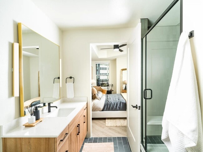 Los baños amplios y luminosos de Modera St. Paul cuentan con acabados elegantes y diseños espaciosos que se conectan perfectamente con su tranquilo dormitorio en Dallas. - Modera St. Paul