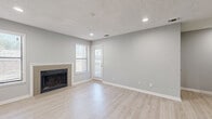 Located at 100 Wood Terrace Place in Atlanta, Georgia, this well-appointed one-bedroom, one-bathroom home offers a practical and comfortable single-floor layout. The combined kitchen and living area forms the heart of the space, bathed in natural light from multiple windows. The living room is anchored by a tile-surround fireplace and features light wood-look flooring, recessed lighting, a textured ceiling, and a door leading directly to a private outdoor area — ideal for easy indoor-outdoor access. Neutral gray walls throughout lend a clean, modern aesthetic. The galley-style kitchen is efficiently designed with ample gray cabinetry, white countertops, black appliances including a refrigerator and dishwasher, and a peninsula that opens toward the living space. The bedroom is a comfortable retreat featuring plush carpeting, a large sliding glass door with access to an outdoor balcony, and generous closet storage supported by two dedicated closet spaces. The bathroom is clean and functional, finished with light wood-look flooring and a full tub-shower combination. This home offers a thoughtful, move-in-ready layout suited for comfortable everyday living in the greater Atlanta area.