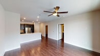 This single-story residence in Houston's Lincoln Heights neighborhood offers a well-designed open-concept layout that seamlessly connects the kitchen, dining, and living areas. Rich, dark hardwood-style flooring runs throughout the main living spaces, complemented by recessed lighting and ceiling fans that enhance both functionality and comfort.

The kitchen is a standout feature, equipped with dark espresso cabinetry reaching toward the ceiling, stainless steel appliances including a refrigerator, electric range, and built-in microwave, and a large island with a single-basin undermount sink and light quartz-style countertops. The island creates a natural division between the kitchen and the open living area, which benefits from sliding glass door access to an outdoor balcony with exterior views.

The bedrooms are carpeted for comfort, each featuring ceiling fans and generous closet space, including a walk-in closet with built-in shelving in one room. Natural light flows in through large windows with views of the surrounding community. The bathroom is cleanly appointed with a soaking tub and shower combo, dark wood cabinetry, and matching flooring, maintaining a consistent aesthetic throughout the unit.