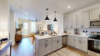 Located at 95 Plum Nelly Circle in Nashville, TN, this one-bedroom, one-bathroom residence offers a well-designed single-floor layout that makes efficient use of its space. The open-concept kitchen and living area serves as the heart of the home, where gray shaker-style cabinetry, quartz countertops, a center island with seating, stainless steel appliances, and striking black pendant lights create a modern yet inviting atmosphere. Wood-style flooring runs throughout the main living areas, adding warmth and continuity. The living room is bright and airy, benefiting from large windows that invite natural light and a ceiling fan overhead. The bedroom is a comfortable retreat, carpeted for added coziness, featuring a ceiling fan, a sizable window with outdoor views, and direct access to a dedicated walk-in closet outfitted with wire shelving systems for organized storage. The bathroom is cleanly appointed with a glass-enclosed shower featuring white tile surround, a quartz-topped vanity, and wood-style flooring. A separate laundry area with additional shelving and wall hooks adds everyday convenience. The overall ambiance is clean, contemporary, and functional — well-suited for comfortable Nashville living.