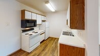 This single-floor unit at 1830 49th St S in Fargo, North Dakota offers a practical and well-organized layout designed for comfortable everyday living. The open entry area flows directly into a combined kitchen and living space, where light wood-style flooring creates a cohesive, clean aesthetic throughout. A ceiling fan overhead adds both comfort and character to this shared zone.

The galley-style kitchen is efficiently designed, featuring white cabinetry on both sides, ample upper and lower storage, a double basin sink, white appliances including an electric range, dishwasher, refrigerator, and microwave, and a window that allows natural light to brighten the workspace.

The living area is generously proportioned, with plush carpeting, a textured ceiling, baseboard heating, and a sliding glass door that opens to an outdoor view, providing an airy, connected feel.

The bedrooms are carpeted and well-lit, each with a window featuring blinds, baseboard heating, and ceiling fixtures. One bedroom includes a ceiling fan for added airflow. The full bathroom is finished with wood-tone cabinetry, a single-sink vanity with a large mirror, a soaking tub with shower, and wood-style flooring, rounding out this straightforward and functional space.