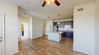 Located on Cahoon Pkwy in Chesapeake, Virginia, this single-floor residence offers a thoughtfully designed open-concept layout that seamlessly connects the kitchen, dining, and living areas. The kitchen is a standout feature, showcasing rich dark espresso cabinetry, granite countertops, a large central island, and a full suite of stainless steel appliances including a refrigerator, range, microwave, and dishwasher. A classic subway tile backsplash adds a clean, modern touch, while pendant lighting above the island provides both function and style. The open living area is bathed in natural light courtesy of multiple large windows that offer views of the surrounding neighborhood. Wood-look plank flooring runs throughout the main living spaces, complemented by a ceiling fan overhead. The bedrooms feature plush carpeting and ample natural light from large windows. The bathroom is well-equipped with a tiled soaking tub and shower combination, a dark-toned vanity with a single sink, and tile flooring. An in-unit laundry area is also visible within the space, adding everyday convenience. Overall, the residence presents a clean, contemporary aesthetic with quality finishes throughout.