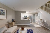 This well-appointed two-story home in Dearborn, Michigan offers a thoughtfully designed layout across two floors. The main level features an open-concept living area with wood-look flooring, neutral gray walls, and large windows that invite natural light. The living room flows seamlessly into a pass-through kitchen outfitted with white shaker cabinetry, stone-look countertops, stainless steel appliances — including a refrigerator, range, and microwave — plus a dedicated pantry closet for additional storage. A convenient laundry area and hallway complete the first floor. A carpeted staircase with white balusters leads to the upper level, where the spacious primary bedroom awaits. This comfortable retreat features plush carpeting, a ceiling fan, multiple windows with outdoor views, and a walk-in closet. The full bathroom on this level is well-equipped with a tub-shower combination, white tile surround, a vanity with stone-look countertops, wood-look tile flooring, and a skylight that adds a bright, airy feel. Two closets provide ample storage throughout the home. The consistent use of neutral tones, modern finishes, and functional layout make this a comfortable and stylish residence.