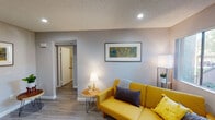 Located at 42200 Moraga Rd in Temecula, CA, this single-floor unit offers a well-designed layout with a comfortable and modern aesthetic. The living area is inviting and versatile, featuring light wood-look flooring, neutral gray walls, recessed lighting, and a textured ceiling. A bright yellow sofa adds a cheerful pop of color, while a ceiling fan and additional seating area with a bar setup provide flexible functionality for relaxing or entertaining.

The kitchen is efficiently designed with white cabinetry, gray countertops, and stainless steel appliances including a gas range, microwave, dishwasher, and refrigerator. A window above the sink allows natural light to filter in, creating a pleasant cooking environment.

The bedroom is a calm retreat, featuring large windows with vertical blinds that invite natural light, soft gray walls, and wood-look flooring that continues throughout the unit. Two full bathrooms serve the space, each equipped with a shower-tub combination, large vanity mirrors, and clean white fixtures, providing comfort and practicality.

Throughout the unit, the consistent use of light flooring, neutral tones, and thoughtful lighting creates a cohesive and welcoming atmosphere that is both functional and stylish.