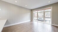 Located at 1338 W Cullerton St, this two-story home offers 4 bedrooms and 5 bathrooms across a well-proportioned layout. The main floor hosts an open-concept kitchen and living area bathed in natural light from large floor-to-ceiling windows and sliding glass doors that provide direct outdoor access. The kitchen is outfitted with high-gloss cabinetry, quartz countertops, a stainless steel range with a wall-mounted hood, and a central island with an undermount sink. Light hardwood flooring runs throughout the living spaces, complementing the neutral gray tones on the walls. The bathrooms feature clean, modern designs with large-format tile, floating vanities with white countertops, and soaking tubs with tile surrounds and handheld shower fixtures. The upper floor provides additional bedroom space, including a generously sized primary bedroom with its own en-suite. Multiple bedrooms across both floors offer sliding glass door and window access to outdoor views, filling rooms with natural light. Three closets and four hallways support strong storage and circulation throughout. The overall ambiance is clean, contemporary, and bright, reflecting a cohesive modern aesthetic with quality finishes throughout.