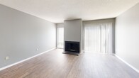 This two-story home in Memphis, Tennessee offers a practical and comfortable layout across two well-proportioned floors. The main level features two living areas, with the primary living room serving as a standout space highlighted by a classic fireplace framed by neutral gray walls and wood-look flooring that flows throughout. Large vertical blinds allow natural light to fill the room. The kitchen is equipped with white cabinetry, laminate countertops, and a full-size refrigerator, with a convenient adjacent laundry area featuring washer and dryer hookups. A half bathroom tucked neatly beneath the staircase completes the main floor. Upstairs, two carpeted bedrooms offer a quieter retreat. The generously sized primary bedroom includes a private en-suite bathroom with a tiled tub-shower combination, while additional closet space adds to its functionality. The second bedroom features plush carpet, natural window light, and ample closet access. A third full bathroom serves the upper level. Throughout the home, a consistent color palette of cool gray tones paired with crisp white trim and textured ceilings creates a clean, cohesive aesthetic. The two-floor design provides a clear separation between living and sleeping spaces.