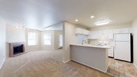This single-floor residence offers a clean, functional layout with a neutral color palette throughout. The open-concept kitchen and living area form the heart of the home, where a peninsula counter with a built-in sink seamlessly connects the two spaces. The kitchen is equipped with white cabinetry offering generous storage, light-toned countertops, a white electric range, and a pass-through window that looks out toward the front entry — enhancing the sense of openness and allowing natural light to flow through. Recessed lighting and a flush-mount fixture provide consistent illumination throughout. Soft, wall-to-wall carpeting covers the living areas and bedrooms, contributing to a warm and comfortable atmosphere. The bedroom is a well-proportioned room featuring dual windows with blinds that invite natural light, along with a baseboard heating unit. An additional carpeted room provides flexible use and includes access to a utility closet housing a water heater. The bathroom features a white vanity with ample counter space, a large mirror with a lighted bar fixture, tile flooring in warm earthy tones, and a full shower-tub combination. The overall design is practical and move-in ready, with a cohesive, understated aesthetic.