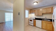 This single-floor residence offers a practical and comfortable layout across two bedrooms and one bathroom. The kitchen is a standout feature, showcasing light maple cabinetry that provides generous storage space, complemented by dark countertops that create a pleasing contrast. White appliances, including an electric range and dishwasher, are seamlessly integrated into the design. Light ceramic tile flooring runs throughout the kitchen, contributing to a clean and bright atmosphere. A window above the range allows natural light to filter into the space, enhancing the open feel of the room. Under-cabinet lighting adds both functionality and warmth to the cooking area. A hallway connects the kitchen to the rest of the home, hinting at a thoughtful and efficient floor plan. The neutral, light-toned walls throughout create a versatile backdrop that suits a variety of interior styles. Overall, this residence combines practical features with a clean, inviting aesthetic, making it a comfortable and functional living space well-suited for everyday living.