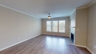 This two-story home offers a thoughtfully designed layout with quality finishes throughout. The main living area is bright and welcoming, featuring warm hardwood-style flooring, crown molding, a ceiling fan, and a tile-surround fireplace flanked by built-in shelving. A large multi-pane window fills the room with natural light and offers views of surrounding greenery, creating an open and airy atmosphere.

The kitchen is well-equipped with crisp white shaker-style cabinetry, light quartz countertops, a subtle tile backsplash, and a full suite of stainless steel appliances, including a range, over-the-range microwave, and a side-by-side refrigerator with an ice and water dispenser. Light wood-tone flooring ties the space together seamlessly.

The bedrooms are carpeted for comfort, each featuring windows with blinds that invite natural light. The primary bedroom is generously sized with dual corner windows, crown molding, and direct access to a spacious en suite bathroom. The primary bath includes an extended double-vanity with quartz countertops, white cabinetry, hardwood-style flooring, and a walk-in closet. Secondary bathrooms are equally well-finished, with white tile tub-shower combinations, quartz vanities, and natural light from windows. The upper level features an open landing area with hardwood-style flooring and recessed lighting, accessible via a staircase visible in the floor plan.