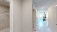 Located at 128 Mill St in Clayton, NC, this contemporary two-story space offers a thoughtfully designed layout spread across two well-proportioned floors. The ground floor and upper level are connected by a striking open staircase with dark wood treads, black metal railings, and cable accents, serving as a bold architectural centerpiece. Smooth, light-colored flooring flows throughout, complemented by crisp white walls and recessed lighting that create a bright, clean aesthetic.

Each floor features its own kitchen, both finished with white shaker-style cabinetry extending to the ceiling, dark granite countertops, classic subway tile backsplashes, and stainless steel appliances including a French-door refrigerator, range, microwave, and dishwasher. Track lighting adds a modern industrial touch overhead.

Two full bathrooms mirror the home's sleek style, each equipped with a white floating vanity, dark granite countertop, large framed mirror, and a multi-light bar fixture. Tile flooring and clean, neutral tones give each bathroom a polished, spa-like feel.

A dedicated laundry room houses a top-load washer with wire shelving for added storage. Two closets and two hallways ensure practical flow between spaces. This space combines modern design with functional versatility throughout.