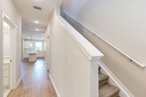 Located at 1387 East Vine Street in Kissimmee, FL, this well-appointed two-story home offers three bedrooms and three full bathrooms across two thoughtfully designed floors. The main level features an open-concept kitchen and living area with warm wood-look flooring that flows seamlessly throughout. The kitchen is a standout, boasting crisp white shaker cabinets, a large central island with a clean white countertop, stainless steel appliances, and pendant lighting that adds a modern touch. Natural light pours in through the windows, enhancing the bright, airy feel of the space. A carpeted staircase with a clean white railing connects the two floors. Upstairs, the bedrooms are finished with plush carpet and ceiling fans, creating comfortable retreats. The generously sized primary bedroom includes a walk-in closet with wire shelving for ample storage. The bathrooms are elegantly appointed with marble-look tile, glass-enclosed showers, white vanities, and brushed gold fixtures. Three dedicated closets across the home provide additional storage. The neutral color palette and modern finishes throughout give this home a clean, contemporary aesthetic ideal for comfortable Florida living.