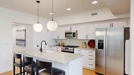 Located at 11 Merrimac Ave in Salt Lake City, UT, this two-story home offers a thoughtfully designed layout across two levels. The main floor hosts an open-concept living, dining, and kitchen area finished with light hardwood flooring and recessed lighting throughout. The kitchen is a standout feature, showcasing white shaker cabinetry with matte black hardware, a subway tile backsplash, quartz countertops, stainless steel appliances including a gas range and French door refrigerator, and a central island with bar seating illuminated by globe pendant lights. The dining area comfortably accommodates a full table and flows seamlessly into the bright living room, which benefits from multiple windows that invite natural light. The primary bedroom is a well-proportioned retreat with recessed lighting and access to a sleek en-suite bathroom featuring a dual-sink vanity, quartz counters, and a glass-enclosed shower. A total of four bathrooms serve the home, all finished in a clean, contemporary style. Additional spaces include five closets, a pantry, a dedicated laundry room, a utility room, and an attached garage on the ground level providing secure parking and extra storage. The overall aesthetic is modern and cohesive, with a neutral palette and quality finishes throughout.