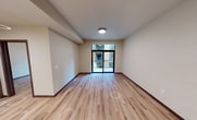 This contemporary 590 square foot apartment, located at 531 W Washington in Madison, Wisconsin, offers a harmonious blend of style and functionality. The single-floor layout maximizes space efficiency, featuring an open-concept design that seamlessly integrates the kitchen and living areas. The 150 square foot primary bedroom provides a generous retreat, while the apartment's large windows flood the space with natural light, creating an airy ambiance.

The kitchen is a standout feature, boasting modern stainless steel appliances, including a refrigerator, stove, and microwave. Sleek cabinetry in a warm wood tone offers ample storage, complemented by a pristine white countertop that doubles as a convenient breakfast bar. The living area, with its expansive windows and sliding glass door, opens onto a private balcony, perfect for enjoying outdoor views.

Throughout the apartment, light-toned wood flooring adds warmth and continuity. The bedroom continues the bright, open feel with large windows and a spacious closet for storage. Modern fixtures, including ceiling fans and recessed lighting, enhance the overall contemporary aesthetic. This well-designed apartment efficiently utilizes every square foot, creating a comfortable and stylish urban living space in the heart of Madison.