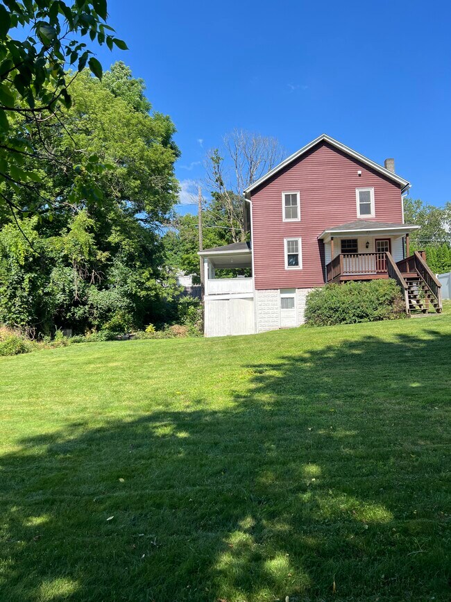 Back deck overlooking flat backyard with lawn and gardens - 103 Sweet Cherry St