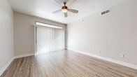 This single-floor residence offers a clean, modern aesthetic throughout, combining functional design with contemporary finishes. The open living area is finished with light wood-look flooring and neutral walls, creating a bright and airy atmosphere. A ceiling fan provides comfort, while vertical blinds cover a wide sliding door that allows natural light to filter into the space.

The kitchen is well-equipped with stainless steel appliances, including a refrigerator, range, and microwave. Two-tone cabinetry — white uppers and gray lowers — pairs with a classic subway tile backsplash and light countertops, lending the kitchen a fresh, modern feel. Durable wood-look flooring continues seamlessly from the living area into the kitchen.

The bedroom features plush carpeting, a ceiling fan, and a window with horizontal blinds that allow for natural light and ventilation. A spacious walk-in closet serves the bedroom, outfitted with dual hanging rods and built-in shelving for generous storage.

The bathroom is neatly designed with wood-look flooring, a gray vanity with a white countertop and under-mount sink, a wall-mounted mirror, and a full tub-shower combination with a window for natural light. Throughout the home, neutral tones and clean lines create a cohesive and move-in ready environment.