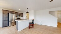 Located at 3355 Union St in North Chili, NY, this three-bedroom, three-bathroom home is thoughtfully laid out across three floors. The main level features an open-concept kitchen and living area with light hardwood-style flooring throughout. The kitchen is equipped with dark espresso cabinetry, stainless steel appliances including a refrigerator, range, microwave, and dishwasher, and a central island with a white countertop and pendant lighting — ideal for both cooking and casual dining. The living area is bright and airy, enhanced by a ceiling fan and a sliding glass door flanked by windows that invite natural light and provide outdoor views. A clean, modern front entry door with sidelights welcomes residents and guests. The upper floors host three carpeted bedrooms, including a generously sized primary bedroom, and well-appointed bathrooms with light, neutral finishes and black hardware accents. A dedicated laundry room includes a full-size washer and dryer. The unfinished basement offers utility space housing mechanical systems and presents opportunity for future use. Throughout, the home maintains a clean, contemporary aesthetic with neutral tones and light flooring, creating a cohesive and inviting atmosphere.