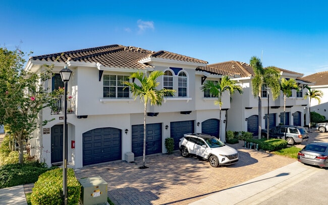 Spacious townhomes with attached garages in a peaceful, palm-lined community. - Bridgewater at Lake Osborne