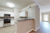 Located in Pearland, TX, this thoughtfully designed single-story residence offers 2 bedrooms and 4 bathrooms across a comfortable, efficiently laid-out floor plan. The living room serves as the heart of the home, featuring light wood-look flooring, crown molding, a ceiling fan, and large windows that invite natural light and provide outdoor views through a glass-paneled door.

The kitchen is a standout feature, showcasing white shaker-style cabinetry, gray quartz-style countertops, a mosaic tile backsplash in neutral tones, and stainless steel appliances. A peninsula with a bar-top counter connects the kitchen to the living area, creating an open and functional flow.

The primary bedroom is generously sized, finished with plush carpet, crown molding, a ceiling fan, and window blinds offering privacy and light control. Three closets throughout the home—including a spacious walk-in with wire shelving—provide ample storage.

The bathrooms are clean and well-finished, featuring white tile surrounds in the tub/shower combinations, wood-look flooring, and white vanities with dark countertops. A dedicated laundry room with side-by-side washer and dryer hookups adds convenience. The overall aesthetic is neutral and modern, with consistent finishes creating a cohesive feel throughout.