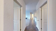 Located in Post Falls, Idaho, this single-floor residence offers four bedrooms and two bathrooms within a well-designed, functional layout. The interior opens through a central hallway lined with white panel doors, connecting the living spaces with ease. Hardwood-style flooring runs through the main corridors and common areas, transitioning to plush carpet in the bedrooms and living room, creating a warm and comfortable feel throughout.

The kitchen is a standout feature, outfitted with white cabinetry, dark countertops, track lighting, and a peninsula that provides additional prep space. White appliances, including a refrigerator, electric range, microwave, and dishwasher, complete the practical setup. Adjacent to the kitchen, the living and dining area is bright and open, with sliding glass doors leading to a balcony and a large window that draws in natural light.

The bedrooms are generously proportioned with carpeted floors, windows with exterior views, and ample wall space. Two closets offer organized storage, including a walk-in closet fitted with wire shelving. The bathrooms feature a clean, neutral aesthetic with a tub-shower combination and hardwood-style flooring. A dedicated laundry room houses a full-size washer and dryer, adding everyday convenience to this well-rounded residence.