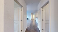 Located in Post Falls, Idaho, this single-floor residence offers four bedrooms and two bathrooms within a well-designed, functional layout. The interior opens through a central hallway lined with white panel doors, connecting the living spaces with ease. Hardwood-style flooring runs through the main corridors and common areas, transitioning to plush carpet in the bedrooms and living room, creating a warm and comfortable feel throughout.

The kitchen is a standout feature, outfitted with white cabinetry, dark countertops, track lighting, and a peninsula that provides additional prep space. White appliances, including a refrigerator, electric range, microwave, and dishwasher, complete the practical setup. Adjacent to the kitchen, the living and dining area is bright and open, with sliding glass doors leading to a balcony and a large window that draws in natural light.

The bedrooms are generously proportioned with carpeted floors, windows with exterior views, and ample wall space. Two closets offer organized storage, including a walk-in closet fitted with wire shelving. The bathrooms feature a clean, neutral aesthetic with a tub-shower combination and hardwood-style flooring. A dedicated laundry room houses a full-size washer and dryer, adding everyday convenience to this well-rounded residence.