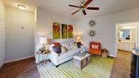 Located at 1402 Bridford Pkwy in Greensboro, NC, this single-floor, 2-bedroom, 2-bathroom home offers a thoughtfully designed layout across a comfortable footprint. The living room is bright and welcoming, featuring wood-style flooring, a ceiling fan, and sliding glass doors that open to a private balcony with outdoor views. Adjacent to the living room, the dining area is bathed in natural light from large windows dressed with decorative curtains, and features a distinctive arched mirror and vibrant green accent wall that adds a lively character to the space. The galley-style kitchen is well-equipped with white cabinetry, light granite-style countertops, stainless steel appliances including a dishwasher, range, and refrigerator, and wood-style flooring throughout. The primary bedroom is generously sized, with plush carpeting, a ceiling fan, and a large window offering natural light and outdoor views. The second bedroom also features a soft green accent wall and direct access to a walk-in closet. Both bathrooms include white vanity cabinetry, granite-style countertops, and framed mirrors with stylish lighting fixtures. A dedicated in-unit laundry area with side-by-side washer and dryer hookups and built-in shelving adds everyday convenience to this well-rounded home.