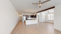 Located at 8681 Edison Plaza Dr in Fishers, Indiana, this single-story residence offers a thoughtfully designed 2-bedroom, 2-bathroom layout. Light wood-style flooring flows throughout the main living areas, complemented by crisp white walls and recessed lighting that create a bright, contemporary ambiance. The open-concept kitchen and living room serve as the heart of the home, anchored by a generous island with a sleek white quartz countertop, undermount sink, and pendant lighting. Dark espresso cabinetry provides striking contrast against a classic white subway tile backsplash, while stainless steel appliances — including a refrigerator, gas range, and microwave — complete the modern kitchen. A dedicated dining area adjoins the living space, with a ceiling fan overhead enhancing the airy feel. Both bedrooms feature plush carpet, ceiling fans, and windows with blinds that invite natural light. The primary bedroom includes access to a well-sized closet, while the second bedroom offers its own closet space. The bathrooms are finished cleanly, with one featuring a tiled walk-in shower. Additional conveniences include a laundry room, utility room, and hallway with louvered closet doors. Three closets throughout the home provide ample storage.