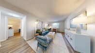 Located on Sutton Circle in Daytona Beach, Florida, this well-appointed two-bedroom, one-bathroom residence offers a thoughtfully designed single-level layout. The open-concept living and dining area is bright and welcoming, featuring wood-look flooring throughout, textured ceilings, and large windows that invite natural light. The living room provides generous space for seating and includes a view through to the dining area, which features a sliding glass door for outdoor access.

The galley-style kitchen is efficiently designed with white shaker cabinetry, white subway tile backsplash, quartz countertops, and stainless steel appliances, including a range, microwave, and dishwasher. A window above the sink adds natural light to the workspace.

The primary bedroom is a comfortable retreat, featuring a ceiling fan, wood-look flooring, and windows with sheer curtains. The second bedroom offers flexibility as a guest room or home office, also with natural light and wood-look flooring. Both rooms share access to a clean, full bathroom with a white-tiled tub-shower combination.

A dedicated closet provides convenient storage, and the neutral color palette throughout creates a cohesive, move-in-ready atmosphere suited to a variety of design preferences.