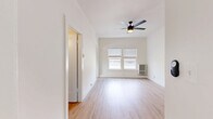 Located at 523 S Westmoreland Ave in Los Angeles, CA, this 2-bedroom, 1-bathroom unit offers a clean, modern aesthetic across a well-organized single-floor layout. Light wood laminate flooring runs consistently throughout the space, creating a warm and cohesive look. The primary bedroom is generously sized, featuring dual windows that invite abundant natural light, a ceiling fan, and a dedicated closet, providing both comfort and functionality. The second bedroom is well-proportioned, also benefiting from natural light through a window with blinds. The kitchen is efficiently designed and equipped with stainless steel appliances, including a gas range, over-the-range microwave, and refrigerator, complemented by gray cabinetry and a window overlooking the surroundings. The bathroom features a clean, contemporary design with white subway tile surrounding the tub and shower, a gray vanity with a white countertop, a framed mirror, and wood-look flooring. A central hallway connects the rooms smoothly, with access to a closet for added storage. Throughout the unit, crisp white walls, ceiling fans, and consistent flooring contribute to a bright, airy ambiance well-suited to urban Los Angeles living.