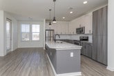 Located at 6271 Riverview Rd SE in Mableton, Georgia, this single-floor residence offers a clean, contemporary design with thoughtful finishes throughout. The open-concept kitchen serves as the heart of the home, showcasing granite countertops, a two-toned cabinet scheme with crisp white upper cabinets and wood-toned lower cabinets, a subway tile backsplash, and a full suite of stainless steel appliances including a range, microwave, and refrigerator. A central island with a built-in sink and pendant lighting above adds both functionality and style, while wood-look flooring ties the space together seamlessly.

A well-lit hallway with the same wood-look flooring connects the main living areas to the private spaces, maintaining a cohesive aesthetic throughout. Bedrooms feature plush carpeting and large windows fitted with blinds, allowing for ample natural light and views of the surrounding neighborhood.

The bathrooms are finished with classic white subway tile surrounds in the tub and shower areas, wood-toned vanity cabinetry, and white countertops. The primary bathroom offers a double-sink vanity and a spacious layout, providing a comfortable and functional retreat. Clean white walls and recessed lighting complete the bright, modern ambiance found throughout this well-designed home.
