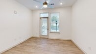 Located at 6930 Prosperity Rd in Huntersville, NC, this single-story residence offers a thoughtfully designed layout across two bedrooms, two bathrooms, a living room, and a kitchen. The interior features a clean, contemporary aesthetic with light wood-style flooring throughout the main living areas and plush carpeting in the bedrooms.

The kitchen serves as a central highlight, showcasing rich dark wood cabinetry, a white subway tile backsplash, granite countertops, stainless steel appliances, and a center island with pendant lighting overhead — creating an inviting space for both cooking and casual dining. The living area features recessed lighting, a ceiling fan, and direct access to the outdoors through a glass door flanked by windows that bring in natural light.

The primary bedroom is a comfortable retreat, featuring carpet flooring, a ceiling fan, and a window with outdoor views. Its en-suite bathroom is well-appointed with granite countertops, dark wood vanity cabinetry, light wood-style flooring, a walk-in glass shower with white tile surround, and access to a spacious walk-in closet with wire shelving systems. The second bedroom includes hardwood-style flooring, recessed lighting, and a window. A second full bathroom mirrors the refined finishes seen throughout, including granite countertops and a soaking tub.