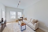 This 630-square-foot, one-bedroom, one-bathroom apartment at Fieldstone on Jericho Turnpike in Commack, NY delivers a clean, modern aesthetic across a single well-organized floor. Light hardwood-style flooring flows throughout, complementing the neutral gray and white color palette.

The open-concept kitchen and living area serves as the heart of the unit. The kitchen features white shaker cabinetry, subway tile backsplash, stainless steel appliances including a refrigerator, range, and microwave, and a white quartz peninsula with pendant lighting and bar seating for three. The adjoining living room benefits from multiple windows that allow generous natural light.

The 110-square-foot bedroom offers a serene retreat, with dual windows, soft neutral tones, and direct access to a dedicated walk-in closet outfitted with built-in shelving and hanging rods for ample storage.

The full bathroom is finished with a white shaker vanity, quartz countertop, framed mirror, subway-tiled tub and shower combination, and contemporary chrome fixtures. The elevated ceilings visible throughout the unit add a sense of spaciousness that extends beyond the square footage.