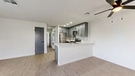 This well-designed 2-bedroom, 3-bathroom single-story residence in San Bernardino, CA offers a cohesive modern aesthetic throughout. The open-concept living and kitchen area serves as the heart of the home, where light wood-style flooring flows seamlessly underfoot. The kitchen is outfitted with gray shaker-style cabinetry, stainless steel appliances including a refrigerator, gas range, and microwave, complemented by a patterned tile backsplash and a white quartz peninsula countertop with an integrated sink — ideal for both cooking and casual dining. A stacked washer and dryer unit is conveniently located just off the kitchen area. The living room is bright and open, with a front-facing window fitted with horizontal blinds that allow natural light to filter in. Both bedrooms are finished with the same light wood-style flooring and feature windows with neighborhood views, providing a calm and neutral retreat. The primary bedroom offers a generous footprint. The three bathrooms maintain a consistent design language with gray vanity cabinetry, white quartz countertops, matte black hardware and fixtures, and well-lit mirrors. The overall interior palette — white walls, gray accents, and light flooring — creates a clean, contemporary living environment.